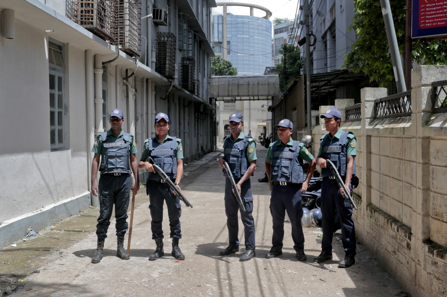 Bangladeshi policemen stand guard outside a morgue at the Dhaka Medical College Hospital during the autopsy on the bodies of suspected Islamic militants who were killed Tuesday in Dhaka, Bangladesh. A Bangladeshi father is having trouble believing that his smart, well-behaved son was among the nine suspected Islamist militants killed in the July 2016, Bangladesh police raid.