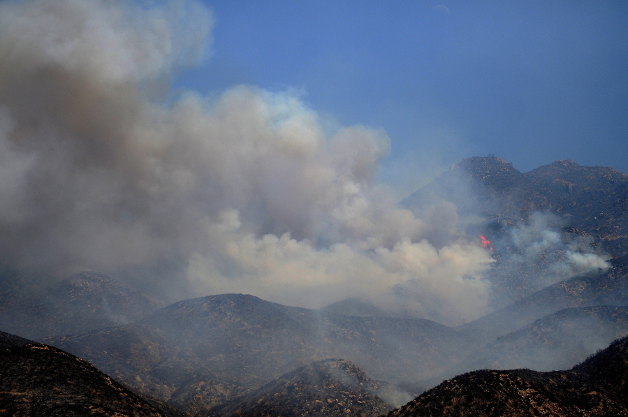 Flames from a wildfire rise up a ridge in Hesperia, Calif., Tuesday. Mandatory and voluntary evacuations covered 5,300 homes in the Southern California fire area between mountain communities around Lake Arrowhead and the high desert city of Hesperia to the north, said Lyn Sieliet, a U.S. Forest Service spokeswoman.