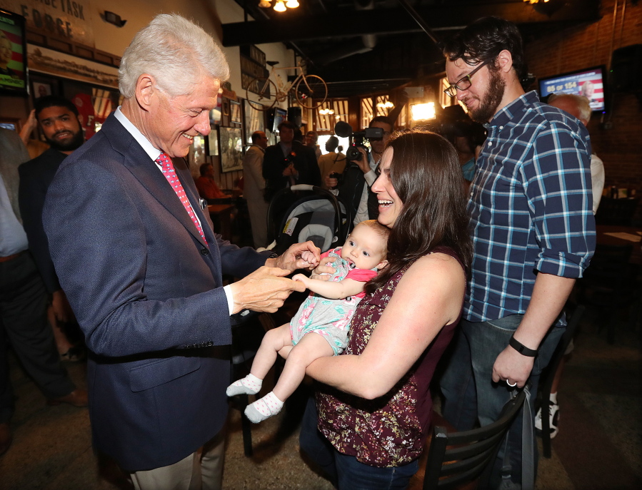 Former President Bill Clinton says hello to Megan Bartlett and her 3-month-old daughter Hannah Rice, Decatur, as he works the crowd at historic Manuel&#039;s Tavern on Wednesday during a stop in Atlanta.