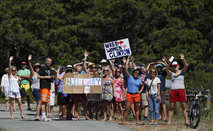 Supporters of Democratic presidential candidate Hillary Clinton cheer outside the gate of Provincetown Municipal Airport in Provincetown, Mass., Sunday, Aug. 21, 2016., before Clinton arrives en route to a fundraiser at the Pilgrim Monument and Provincetown Museum in Provincetown, Mass.