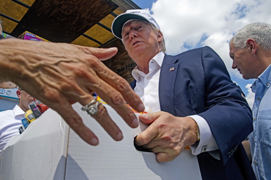 Donald Trump and his running mate, Indiana Gov. Mike Pence, right, help unload supplies for flood victims Friday in Gonzales, La.