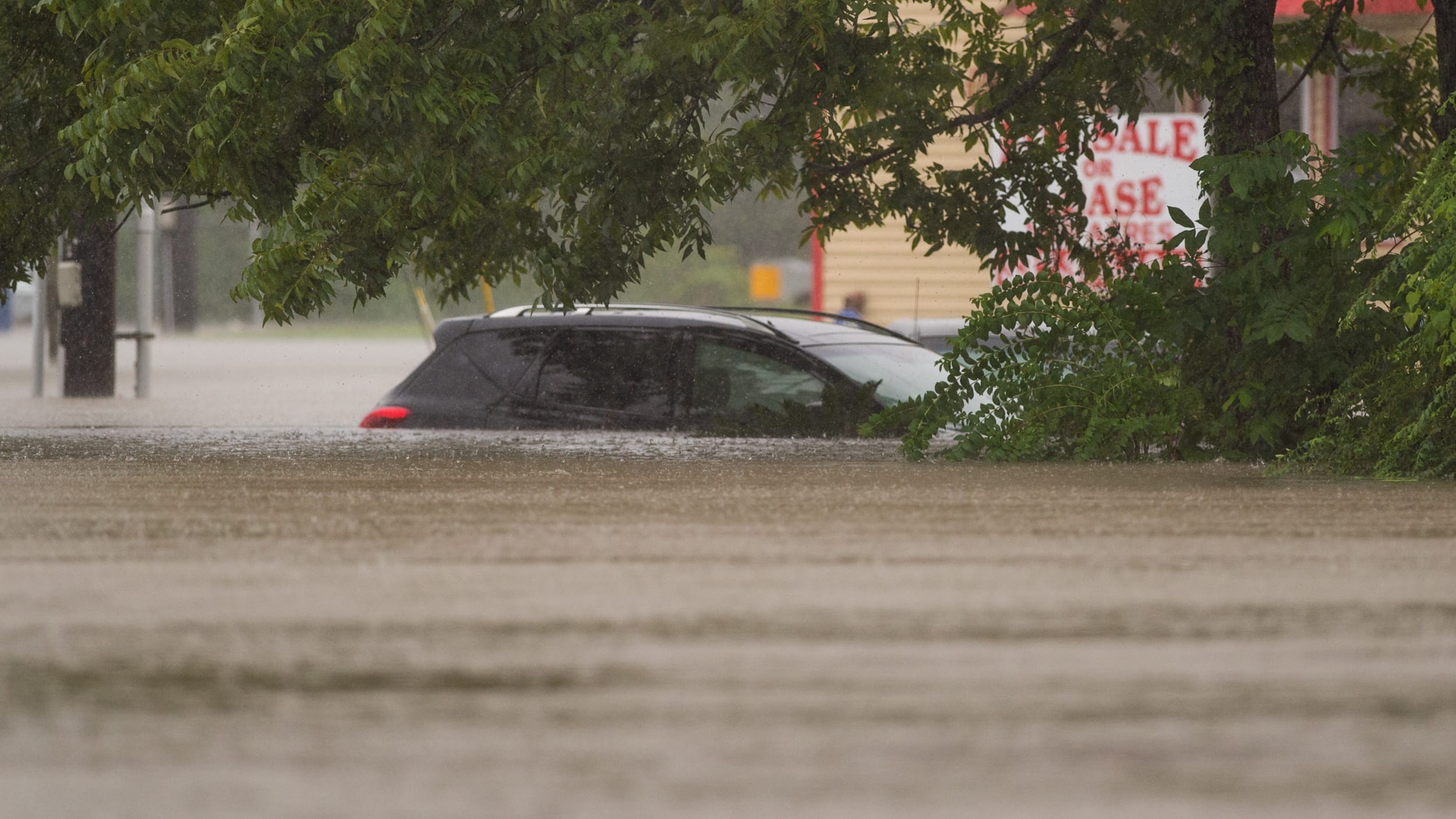 A car sits submerged in a flooded residential neighborhood in Carencro, La., Saturday, Aug. 13, 2016, as record rainfall causes flooding across south Louisiana.