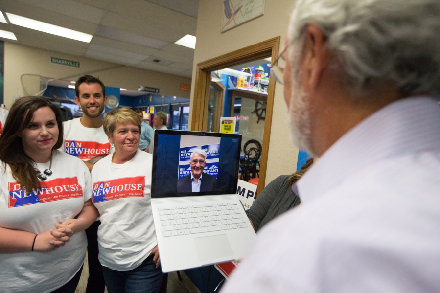U.S. Congressional District 4 candidate Rep. Dan Newhouse, right, talks with candidate for governor Bill Bryant, center, over Skype at Sharky&#039;s Pizza Shack in Yakima on Tuesday.