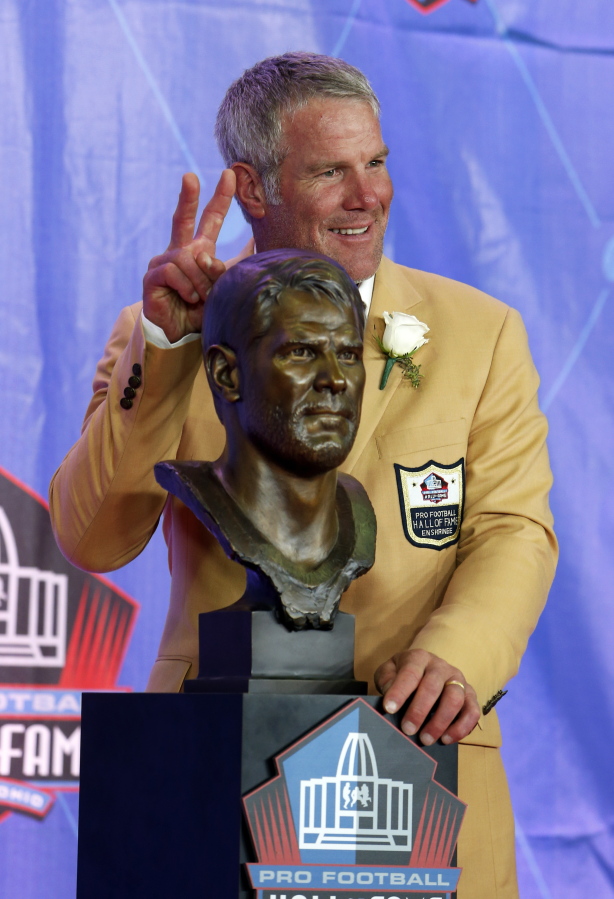 Former NFL quarterback Brett Favre poses with a bust of himself during an induction ceremony at the Pro Football Hall of Fame on Saturday, Aug. 6, 2016, in Canton, Ohio.