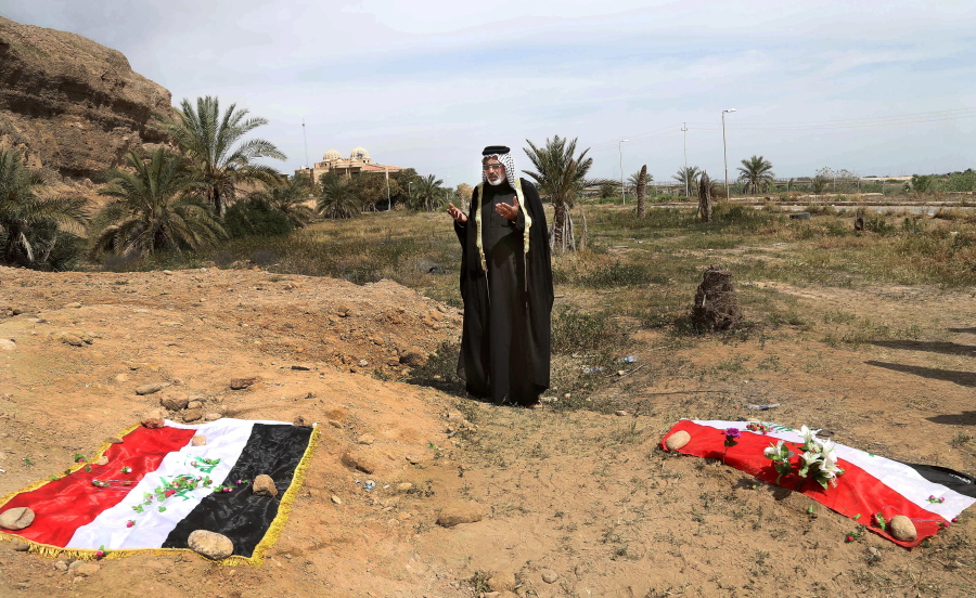 An Iraqi man prays for his slain relative at the site of a mass grave believed to contain the bodies of Iraqi soldiers killed by Islamic State group militants when they overran Camp Speicher military base in Tikrit, Iraq, in June 2014.  An analysis by The Associated Press has found 72 mass graves left behind by Islamic State extremists in Iraq and Syria, and many more are expected to be discovered as the group loses territory.