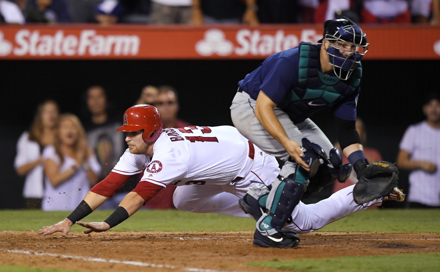 Los Angeles Angels&#039; Jett Bandy, left, dives into home safely on a triple by Cliff Pennington as Seattle Mariners catcher Mike Zunino takes a late throw during the eighth inning of a baseball game, Tuesday, Aug. 16, 2016, in Anaheim, Calif. The Angels won 7-6. (AP Photo/Mark J.