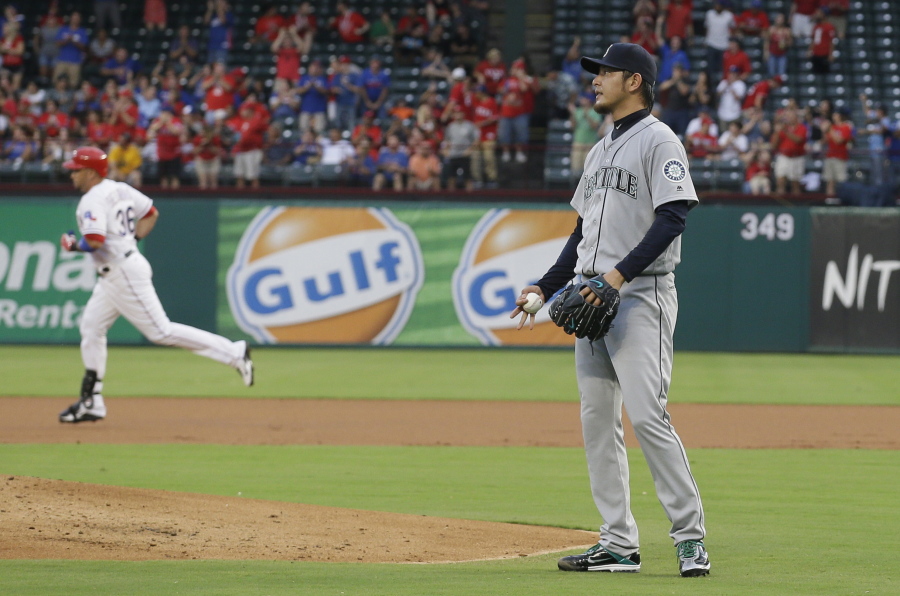 Texas Rangers Carlos Beltran, left, runs the bases as Seattle Mariners starting pitcher Hisashi Iwakuma, of Japan, looks on after Beltran&#039;s solo home run during the first inning of a baseball game in Arlington, Texas, Monday, Aug. 29, 2016.
