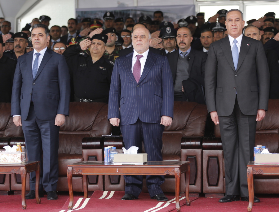 FILE -- In this Jan. 9, 2016 file photo, Iraqi Prime Minister Haider al-Abadi, center, then Defense Minister Khaled al-Obeidi, right, then Interior Minister Mohammed al-Ghabban, left, attend a ceremony marking Police Day, in Baghdad, Iraq. Recent political upheaval has left Iraq without a minister of defense or interior as the country prepares for the operation to retake Mosul -- expected to be the most complicated yet in the fight against the Islamic State group. Al-Obeidi was abruptly dismissed by a parliamentary no-confidence vote Thursday, Aug. 25, 2016, for reasons that seem to have little to do with his performance in office. Al-Ghabban submitted his resignation in early July amid mounting anger following a massive truck bombing claimed by IS that killed more than 300 people.