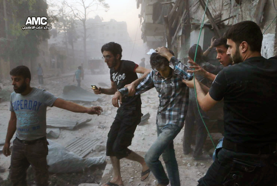 This image provided by the Syrian anti-government activist group Aleppo Media Center shows people helping an injured man, center, after airstrikes hit Aleppo, Syria, on July 31.