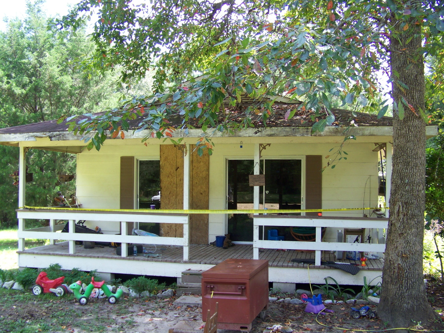 Crime scene tape marks the home on Jim Platt Road near Citronelle, Ala., on Sunday where authorities said five people were killed on Saturday. Police said that Derrick Dearman, 27, of Leakesville, Miss., has been taken into custody in connection with the murders.