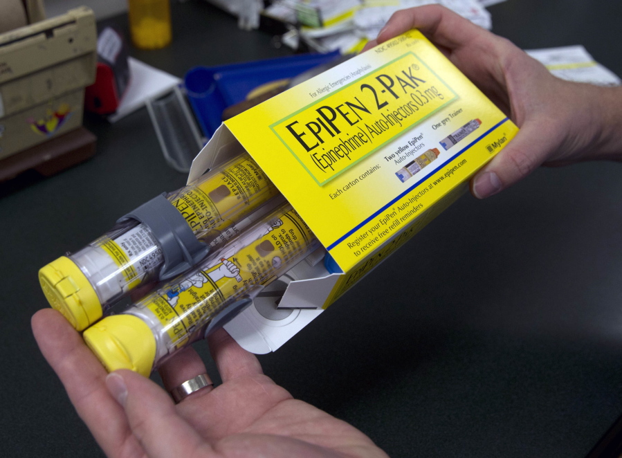A pharmacist holds a package of EpiPens epinephrine auto-injector, a Mylan product, in Sacramento, Calif.