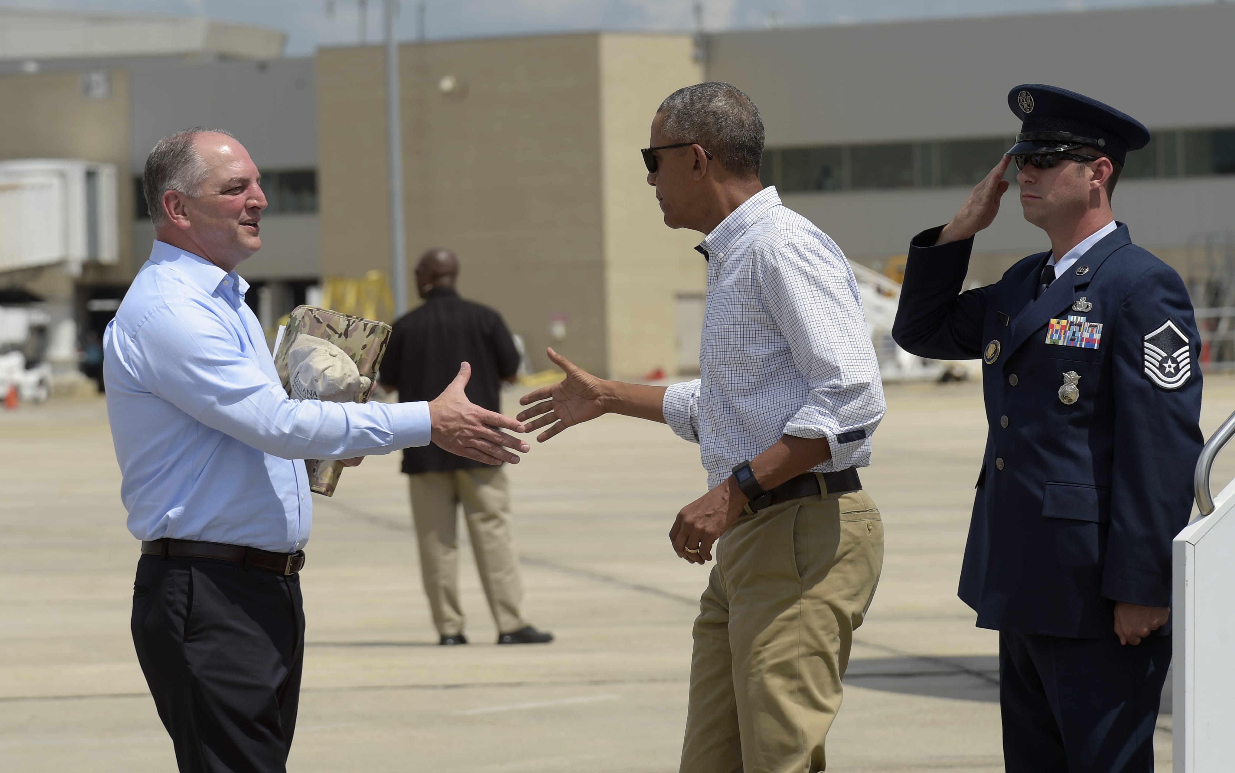 President Barack Obama reaches to shake hands with Louisiana Gov. John Bel Edwards, after arriving on Air Force One at Baton Rouge Metropolitan Airport in Baton Rouge, La., Tuesday, Aug. 23, 2016. Obama is traveling to the area to survey the flood damage.