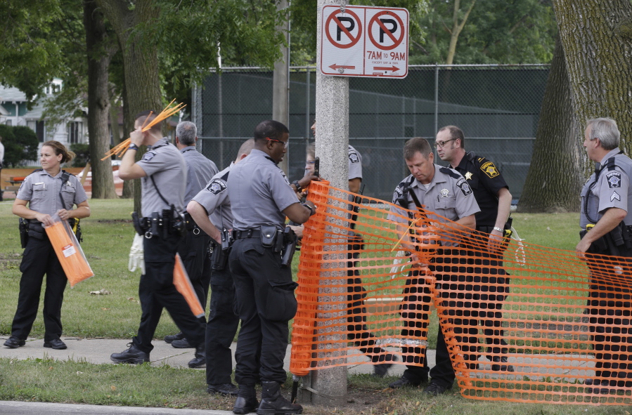 Police prepare to close a park Monday in Milwaukee following several nights of protests and violence.