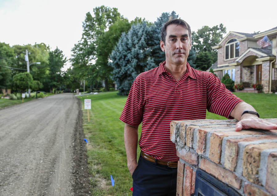 Bill Manhart stands in front of his house along 113th Street in Omaha, Neb. The city had ground-up the asphalt surface of the street saying it was beyond repair and replaced it with a gravel road. After vocal opposition from Omaha residents, the city changed its two-year-old street-grinding policy, and the Mayor announced the city would stop grinding up streets unless requested by residents and would pay half the cost of repaving three stretches of badly deteriorated road.