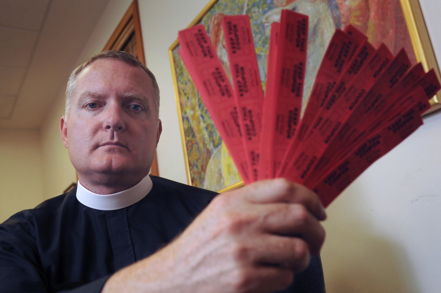 In this photo, Rev. Jeremy Lucas of Christ Church Episcopal Parish holds the 150 tickets that he purchased in an all-star softball team&#039;s raffle to win an AR-15 assault rifle in Lake Oswego, Ore.