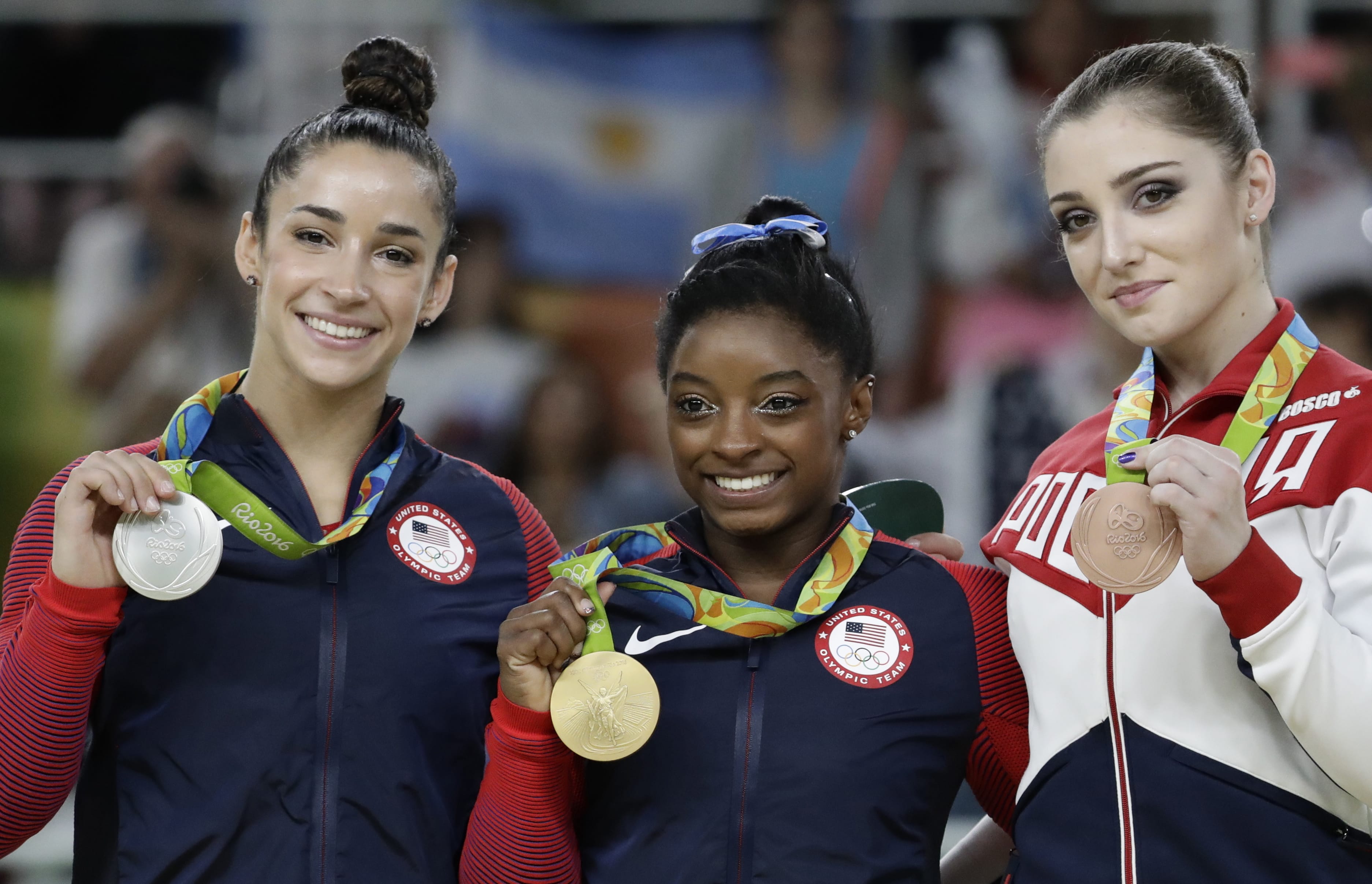 Bronze medallist Russia's Aliya Mustafina, right, gold medallist United States' Simone Biles, center, and silver medallist United States' Aly Raisman display their medals for the artistic gymnastics women's individual all-around final at the 2016 Summer Olympics in Rio de Janeiro, Brazil, Thursday, Aug. 11, 2016.