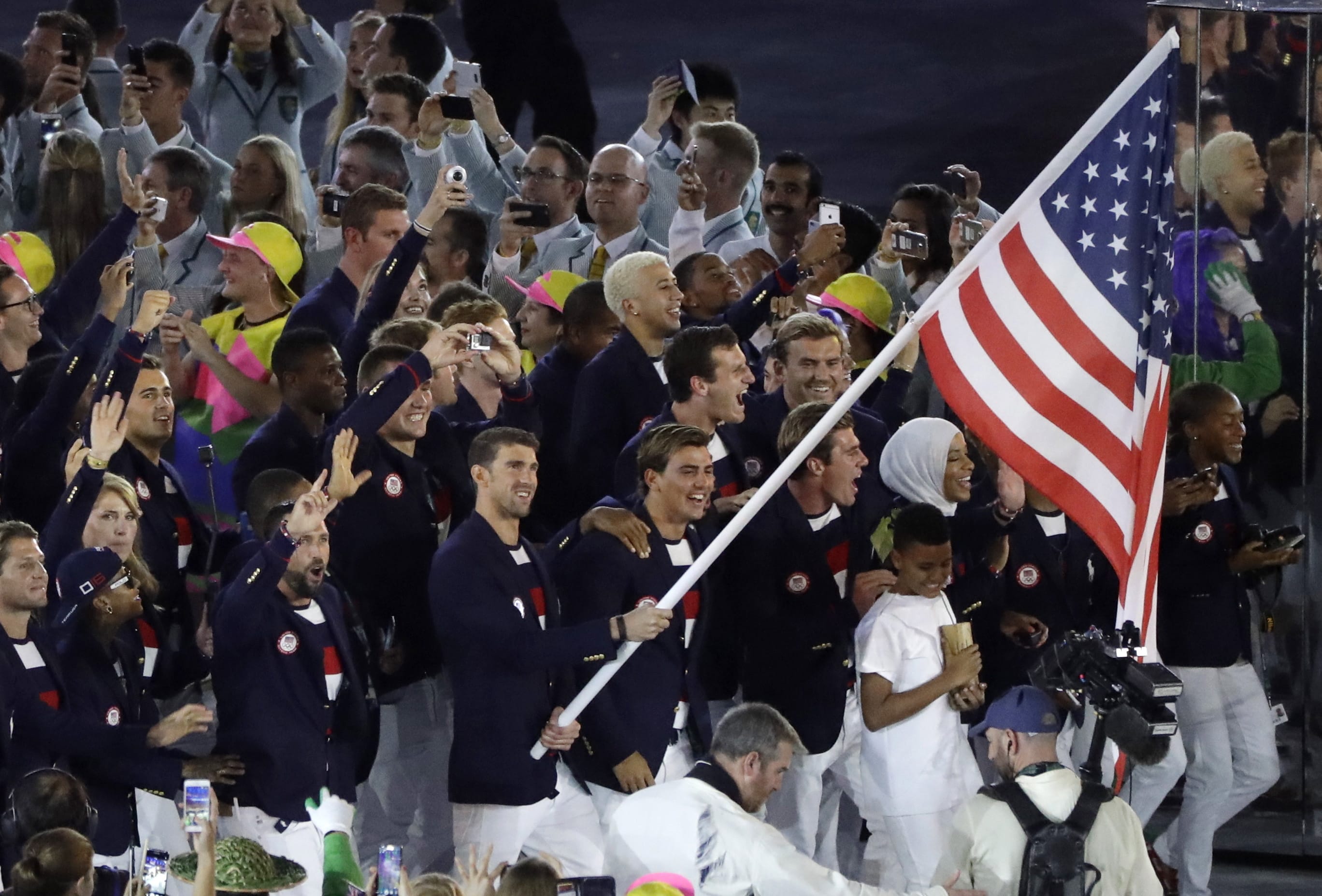 Michael Phelps carries the flag of the United States during the opening ceremony for the 2016 Summer Olympics in Rio de Janeiro, Brazil, Friday, Aug. 5, 2016. (AP Photo/Jae C.
