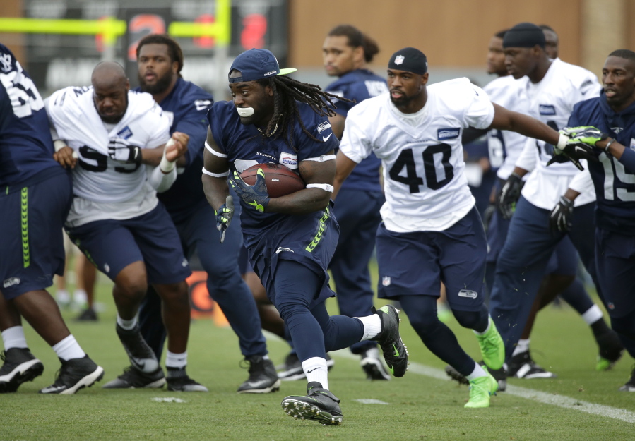 Seattle Seahawks running back Alex Collins, center eft, carries the ball during NFL football training camp, Saturday, Aug. 6, 2016, in Renton, Wash. (AP Photo/Ted S.