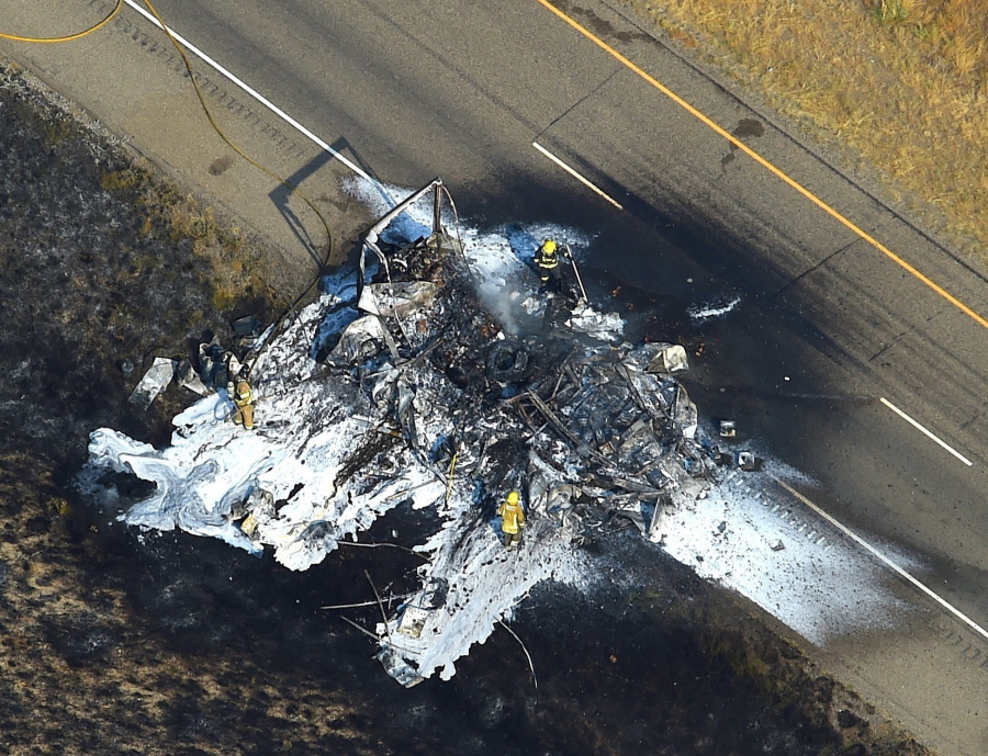 Firefighters work at the wreckage of a truck that burned and closed Interstate 94 near Huntley, Mont. The Montana Highway Patrol says a FedEx tactor-trailer was towing three trailers when an apparent brake system malfunction caused the fire just before 4 p.m. Wednesday. The truck driver was not injured.