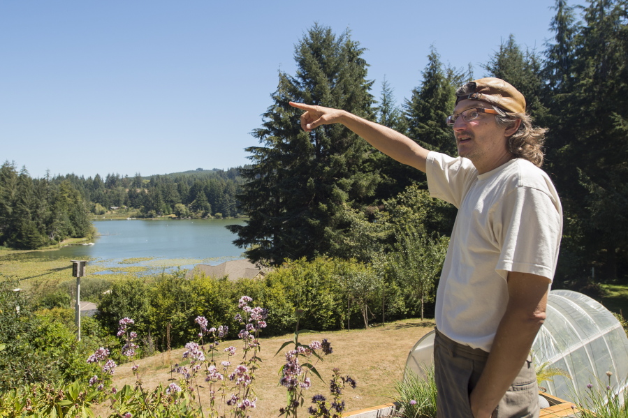 Steven DuBois points to Lake Siltcoos, near Dunes City, Ore., earlier this month. Residents living near Oregon&#039;s Siltcoos Lake are having problems with their water supply. They draw water of questionable quality from the algae-choked lake.