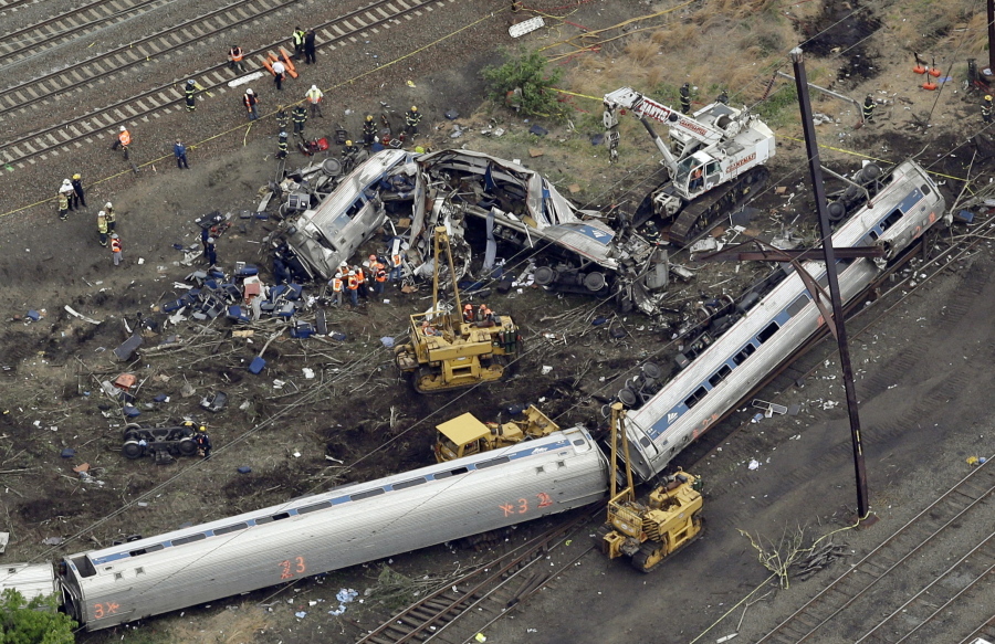 Emergency personnel work at the scene of a derailment in Philadelphia of an Amtrak train headed to New York on May 13, 2015.  Many commuter and freight railroads have made little progress installing safety technology designed to prevent deadly collisions and derailments despite a mandate from Congress, according to a government report released Wednesday, Aug. 17, 2016.