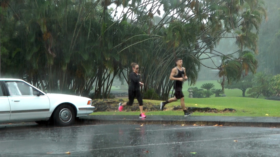People jog as the rain falls Wednesday in Hilo, Hawaii.