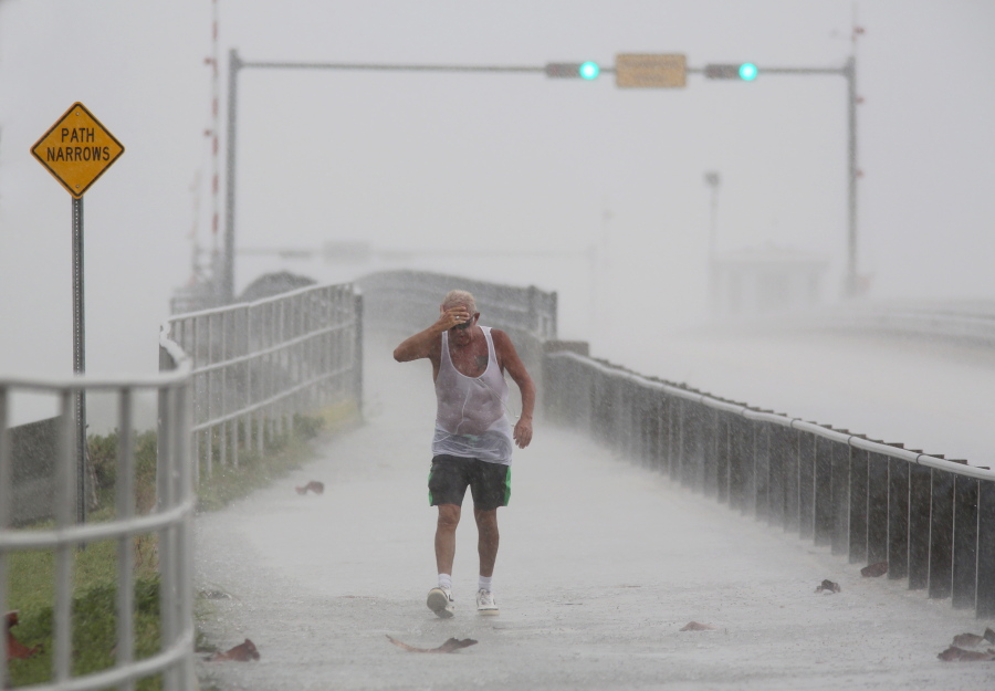Rain pummels Steve Pearson, of Clearwater, Fla., on a walk Monday on the Dunedin Causeway. Thunderstorms moved through Pinellas County, bringing wind and heavy rain in Dunedin, Fla. (Douglas R.