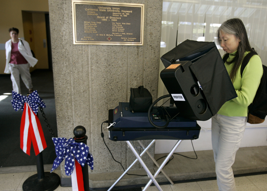 California State University Hayward student Martha Nguyen Le votes on a portable voting machine with a printer in 2006, on campus in Hayward, Calif.