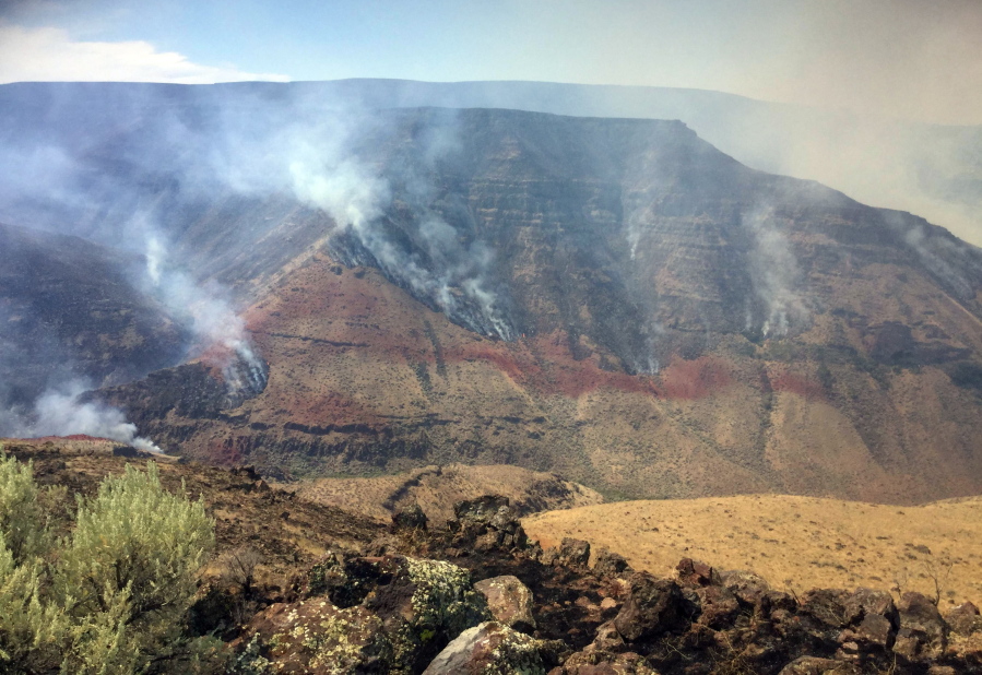 A wildfire smolders on the northwest side of Owyhee Canyon south of Vale, Ore., Wednesday, Aug. 24, 2016. The nearly 50-square-mile fire in eastern Oregon near the Idaho state line is now threatening Succor Creek State Park.