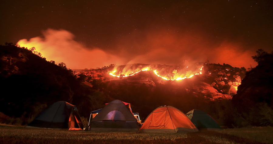Campers bed down for the night along Putah Creek as the Cold Fire burns slowly downhill on the Solano and Napa counties line Tuesday near Lake Berryessa, Calif.