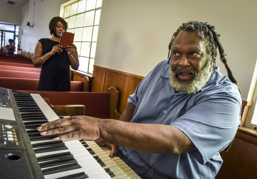 Tim Kimbrough, right, a keyboard player who invented his own musical notation system, warms up at the organ in Bladensburg, Md.