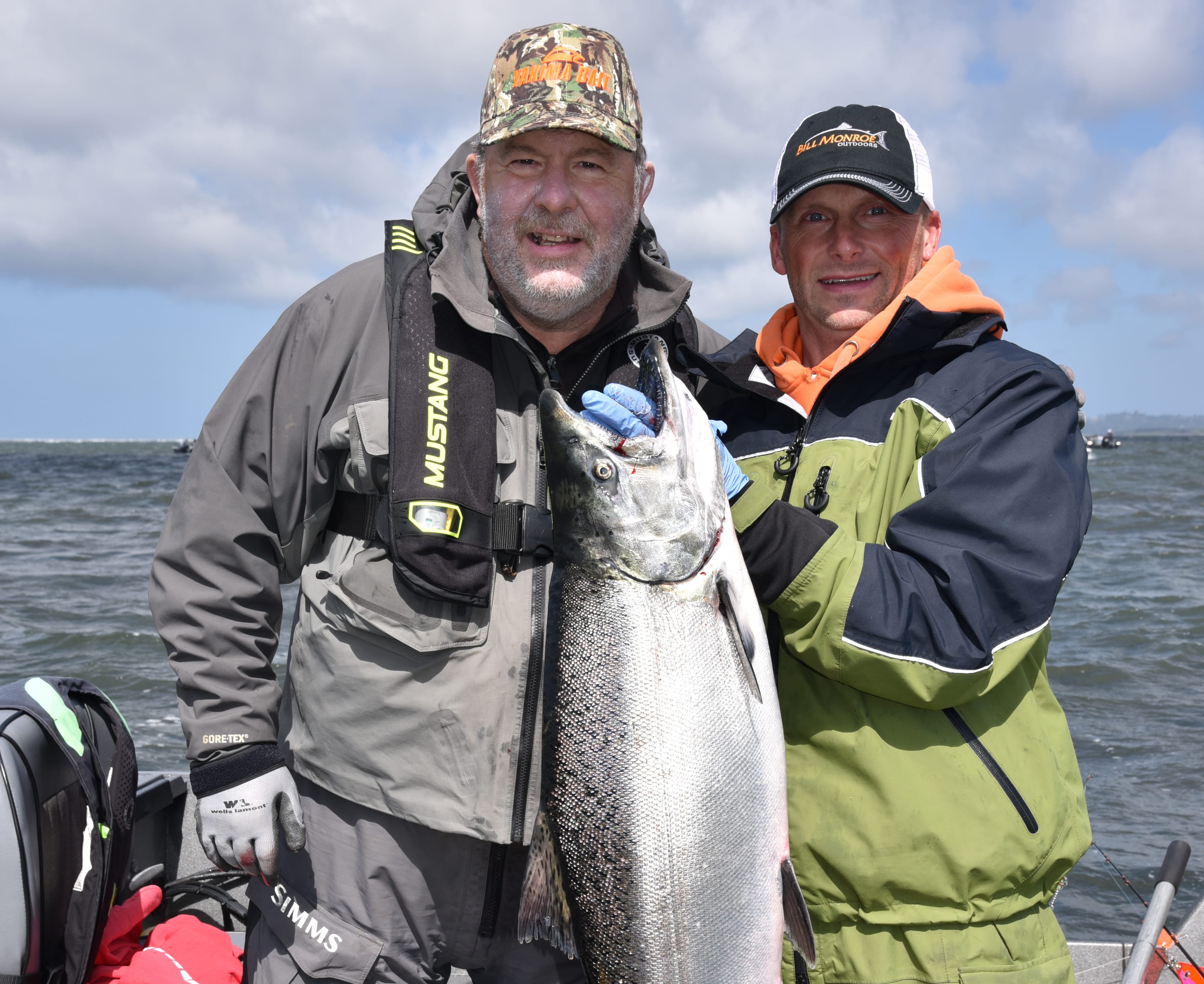 Oregon angler Randy Woosley, left, holds a nice chinook he landed at Buoy 10 with guide Bill Monroe Jr.