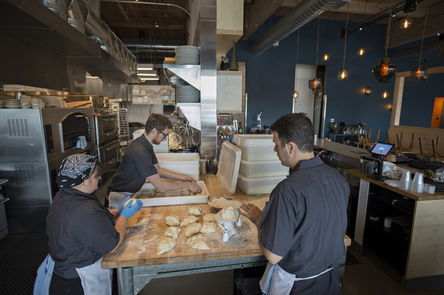 Master baker Melissa Ayers, left, prepares dough for pizza with sous chef Cameron Winchester, center, and chef-owner Alan Maniscalco on Tuesday afternoon at Rally Pizza.