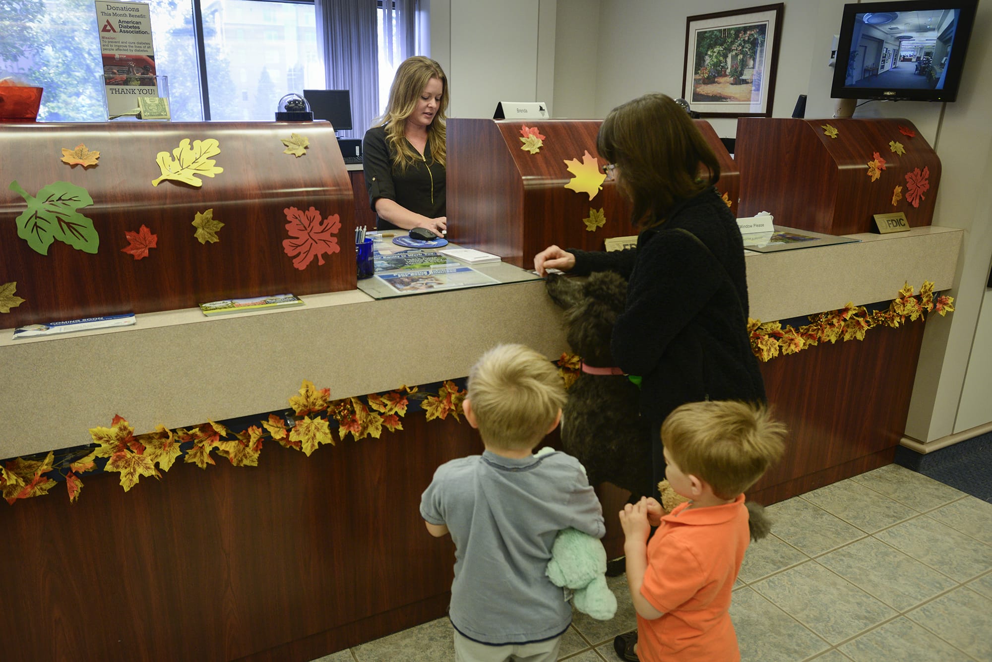 Riverview Community Bank teller Brenda Wilson helps customers at the downtown Vancouver Riverview location Thursday.