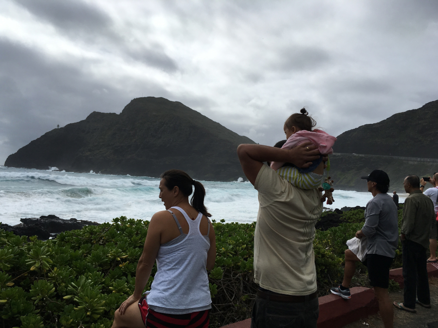 Bert Hartsock carries his 1-year-old daughter, Maya, on his shoulders as they and his wife, Tia, watch the surf Saturday at Makapuu Beach in Waimanalo, Hawaii.