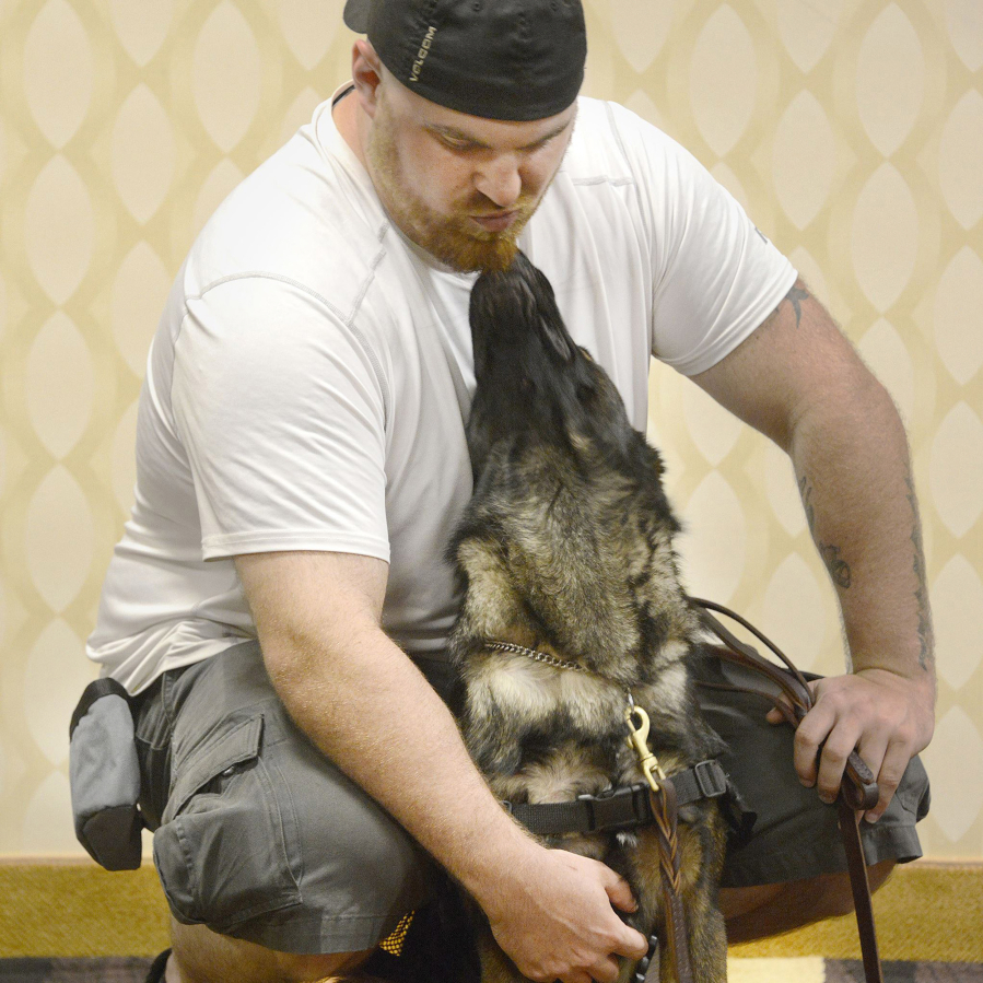 Mitchell Baldwin gets a kiss from Oliver, a 22-month-old Guardian Angels Medical Service dog.
