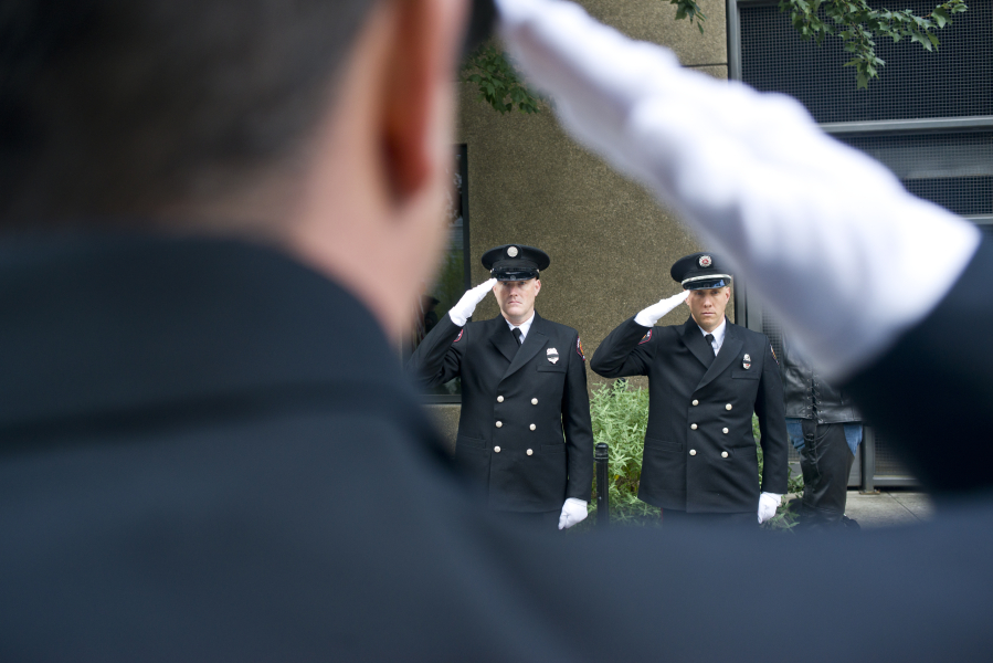 Captain Tyler Dillmon, left, and Marc Patchin, are framed by fellow Vancouver fireman Joe Hudson in salute during the Patriot Day ceremony at Vancouver City Hall on Sunday, Sept. 11, 2016. The ceremony was held in remembrance of the nearly 3,000 people who died in the terrorist attacks on September 11, 2001.