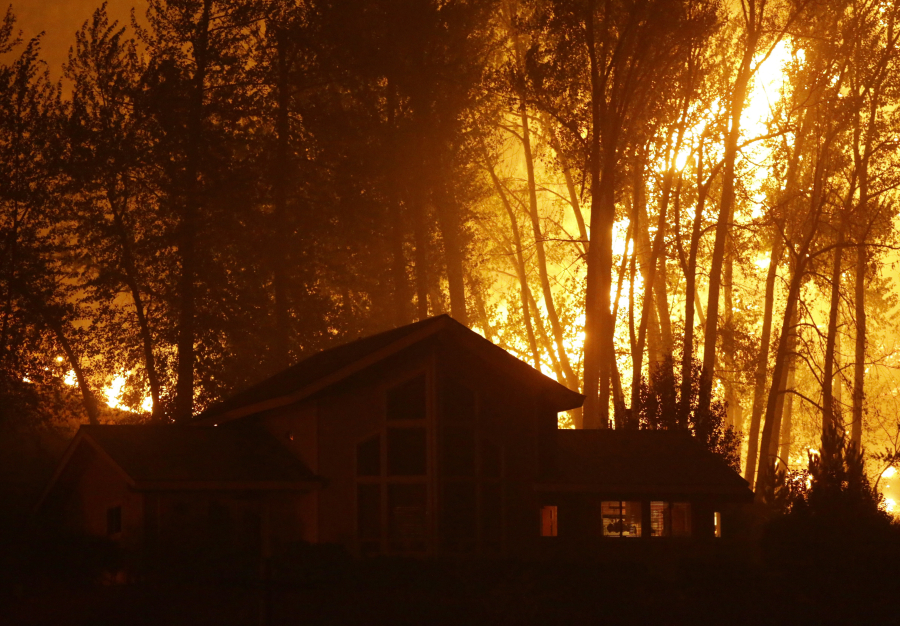 The Okanogan Complex Fire burns behind a home in Twisp on Aug. 20, 2015.