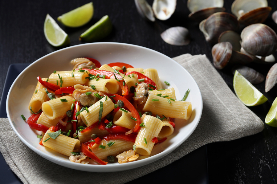 Fresh clams are mixed with tubular pasta and sweet and hot peppers.