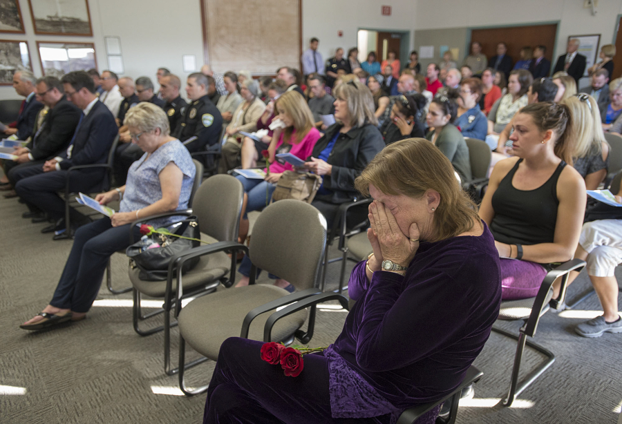 Mary Allison of Amboy, foreground, mourns her sister, Sharon Allison, as taps is played during the National Day of Remembrance for Homicide Victims ceremony Monday at the Clark County Public Service Center. Allison died from blunt-force head trauma in her Vancouver apartment in May 2015. Investigators believe she was struck in the head with a lamp.