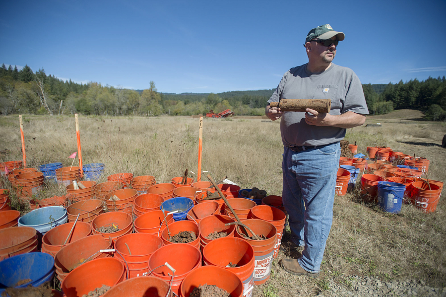 Munitions safety adviser Greg Johnson holds a World War I-era Stokes mortar Friday afternoon at Camp Bonneville. The U.S. Army this week pledged an additional $1.76 million to cleanup efforts at the 3,840-acre site, which will eventually be converted to a park.
