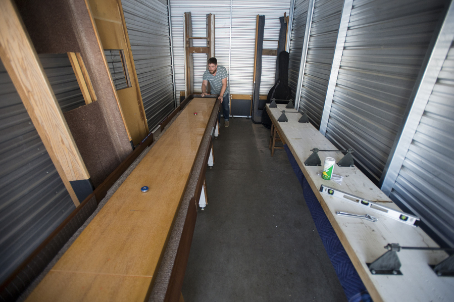 James O&#039;Brien plays shuffleboard in a storage unit he rented before moving into a shop in east Vancouver. Through their business, O&#039;Brien and his wife, Sara O&#039;Brien, plan to supply and service local tables while reinvigorating the local shuffleboard scene.