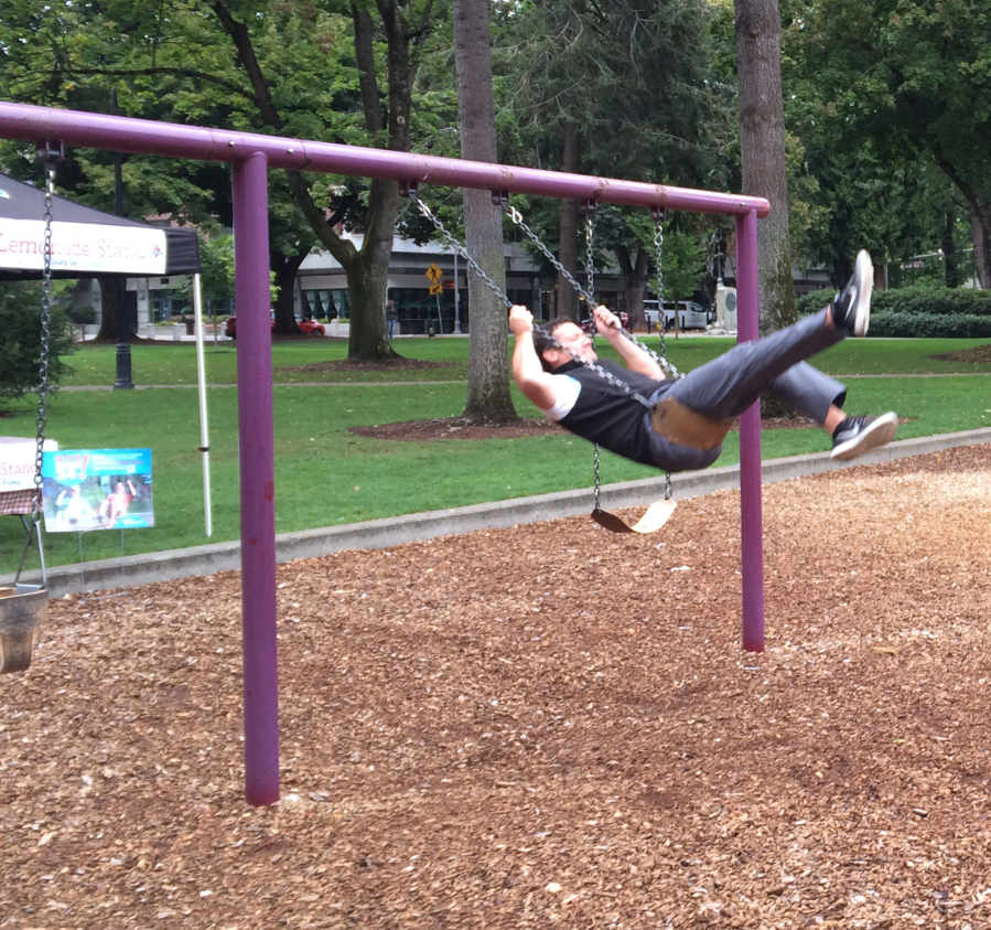Vancouver Mayor Tim Leavitt takes his turn on the playground swings as part of the Give More 24! fundraisers held Thursday.