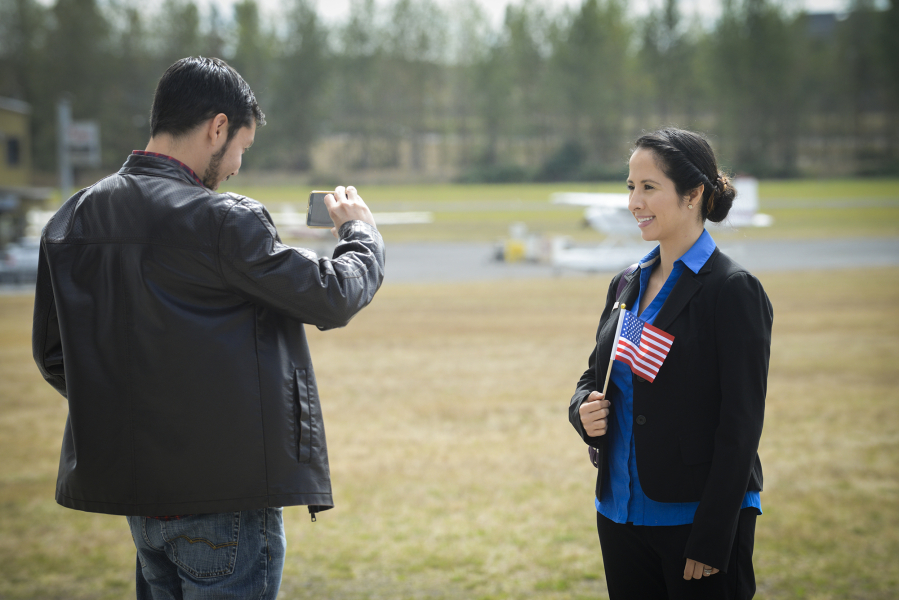 Erick Romero, left, takes a photo of his wife, Lorena Topete, a native of Mexico, outside Pearson Air Museum in Vancouver on Wednesday following a naturalization ceremony for 21 new American citizens.