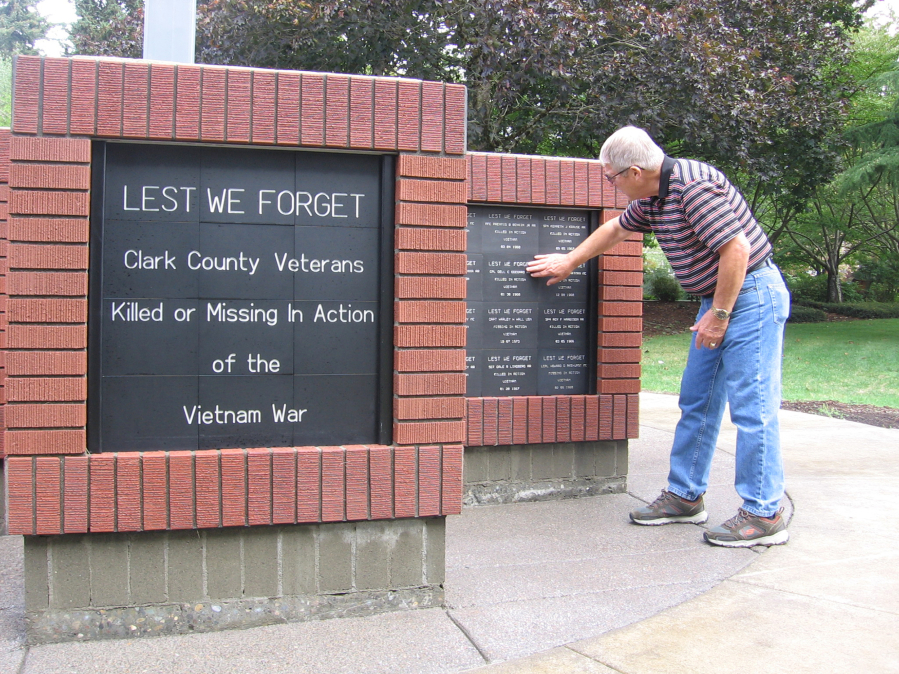 Larry Smith, co-chairman of the Community Military Appreciation Committee, takes a closer look Tuesday at plaques on the Clark County Vietnam Memorial.