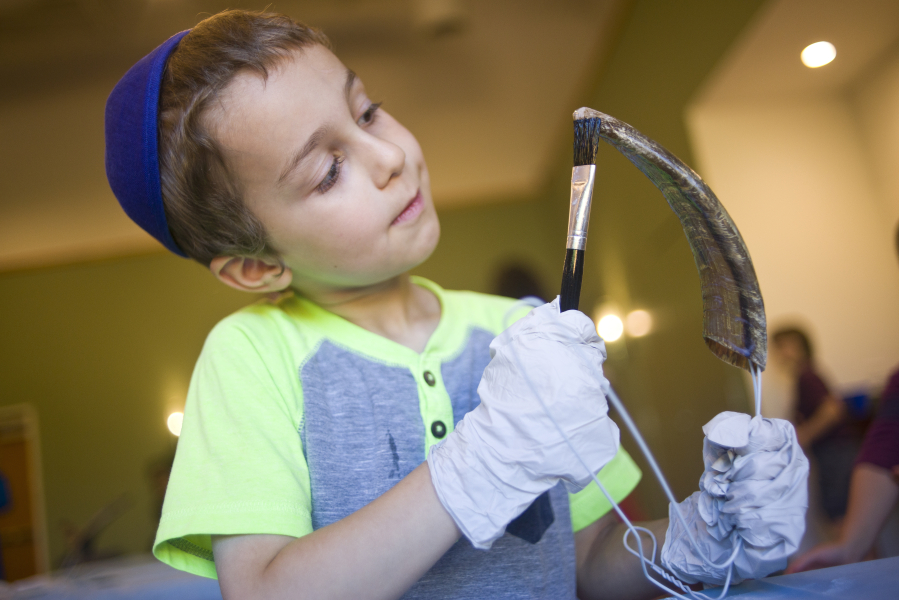 Sroli Greenberg, 5, gives his shofar a good shellacking during a Shofar Factory Holiday Workshop at the Chabad Jewish Center in Clark County on Sunday. Children were given the opportunity to finish a shofar, a ram&#039;s horn blown during the Rosh Hashanah, which begins Oct. 2 at sundown.