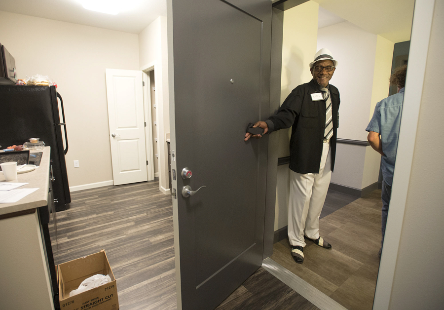 Resident Karl Colbert holds the door open for visitors Wednesday morning while showing off his new apartment at Freedom&#039;s Path.