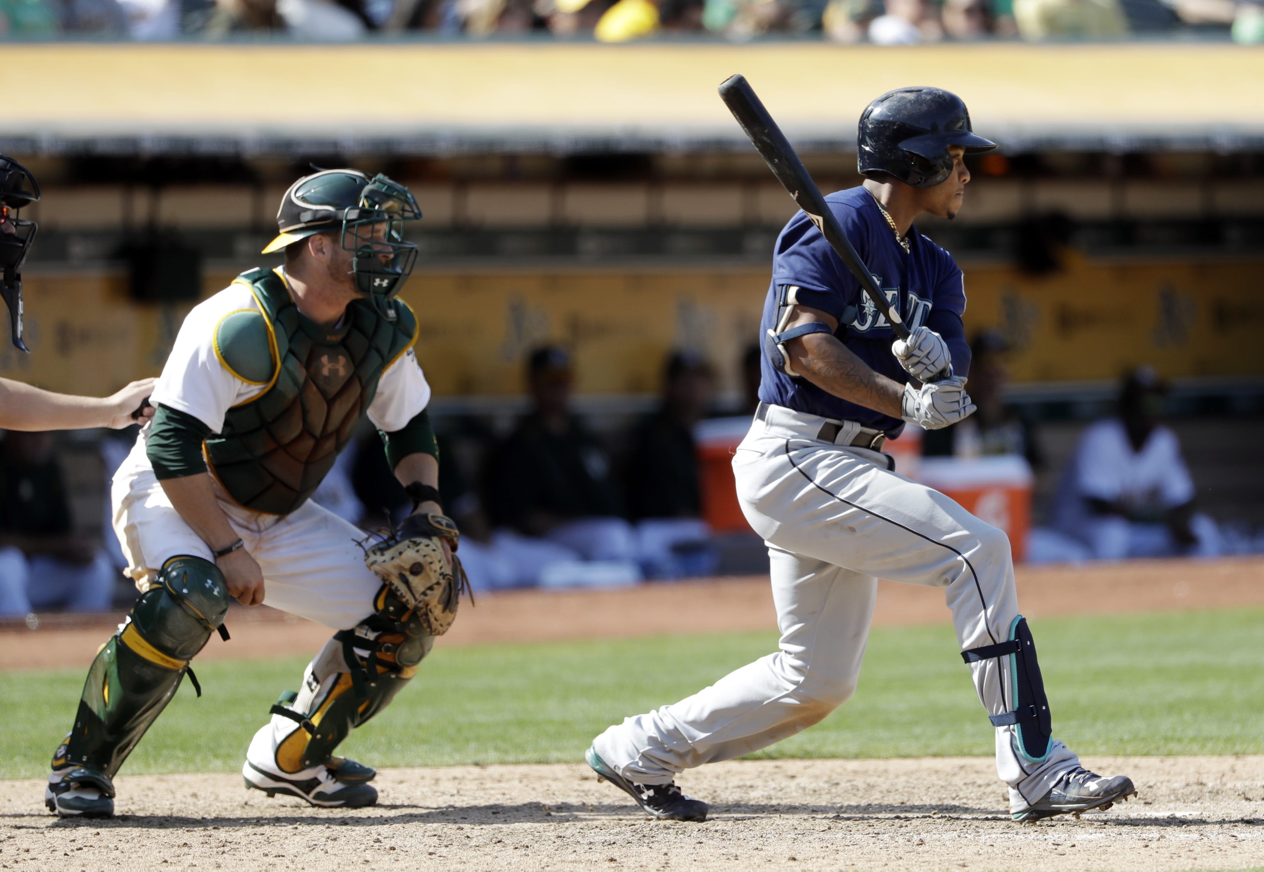 Seattle Mariners' Ketel Marte, right, drives in a run with a single during the ninth inning of a baseball game against the Oakland Athletics, Sunday, Sept. 11, 2016, in Oakland, Calif.