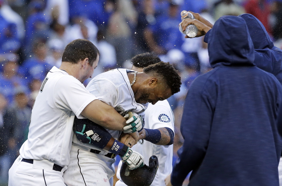Seattle Mariners&#039; Mike Zunino, left, holds Robinson Cano as other players douse Cano with water after his game-winning sacrifice fly against the Toronto Blue Jays on Wednesday in Seattle. The Mariners won 2-1 in 12 innings to remain in the hunt for an American League wild card.