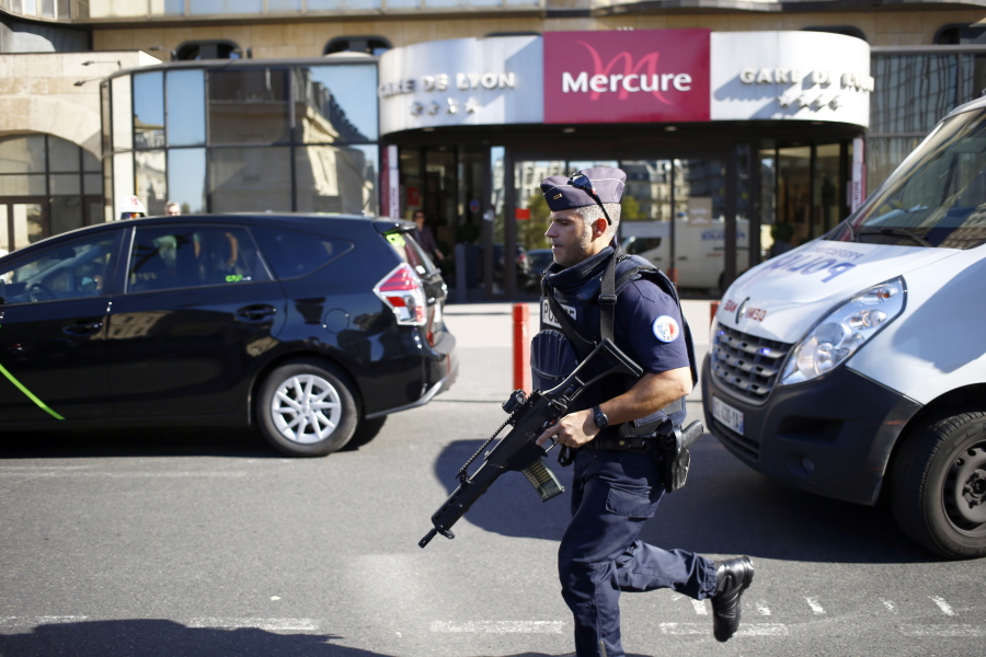 A police officer runs Friday to take position during a bomb scare at Gare de Lyon railway station in Paris, France. A failed attack involving a car loaded with gas canisters near Notre Dame Cathedral was spearheaded by a group of women that included a 19-year-old whose written pledge of allegiance to the Islamic State group was found by police, a security official said Friday.